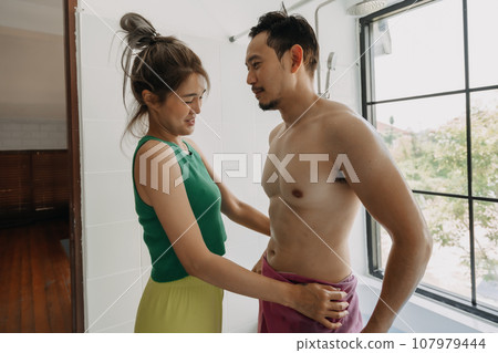 Funny and playful couple, wife helping husband after taking bath. Funny and playful couple, wife helping husband after taking bath. 107979444