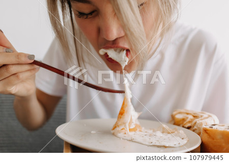 Funny face of woman putting breakfast into her mouth. Concept of dietary. 107979445