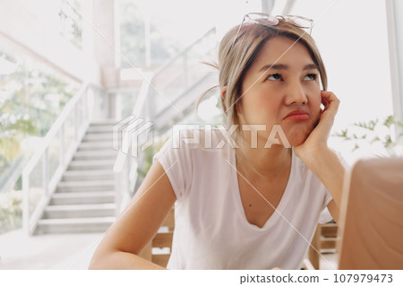 Serious and unpleasant face of woman work and solving problem on the laptop. 107979473