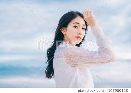 Beauty image of a young woman with blue sky background Beauty image of a young woman with blue sky background 107980128