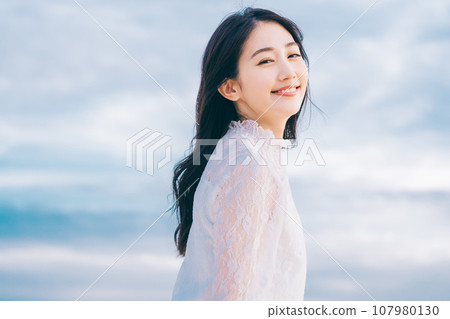 Beauty image of a young woman with blue sky background Beauty image of a young woman with blue sky background 107980130
