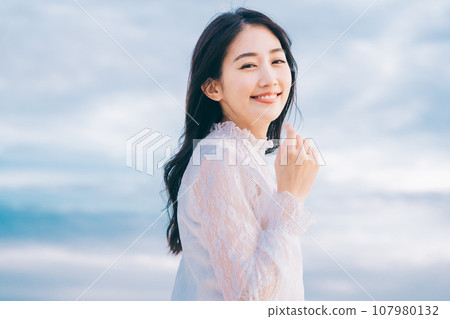 Beauty image of a young woman with blue sky background 107980132