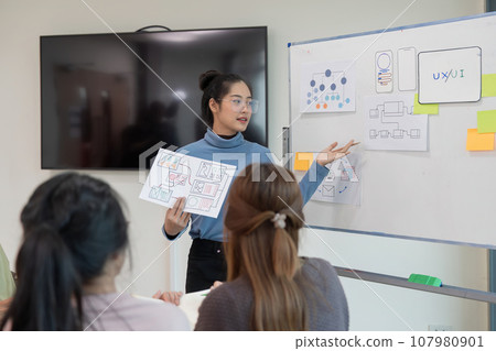 ux developer and ui designer presenting and testing mobile app interface design on whiteboard in meeting at modern office. Creative digital development mobile app ux developer and ui designer presenting and testing mobile app interface design on whiteboard in meeting at modern office. Creative digital development mobile app 107980901