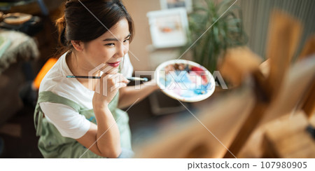 Talented Female Artist Working on a artist lifestyle. painting hobby. woman drawing beautiful watercolor design Talented Female Artist Working on a artist lifestyle. painting hobby. woman drawing beautiful watercolor design 107980905
