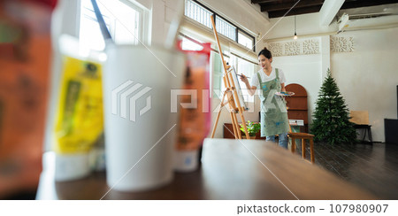 Talented Female Artist Working on a artist lifestyle. painting hobby. woman drawing beautiful watercolor design Talented Female Artist Working on a artist lifestyle. painting hobby. woman drawing beautiful watercolor design 107980907