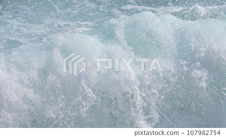 Waves crashing with splashing water 107982754