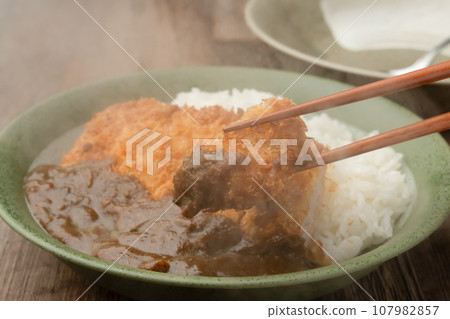 用筷子夾咖哩肉排 用筷子夾咖哩肉排 107982857
