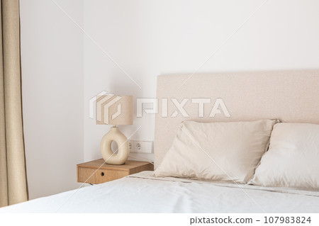 Lamp on night stand near leather bed in minimalist bedroom Lamp on night stand near leather bed in minimalist bedroom 107983824