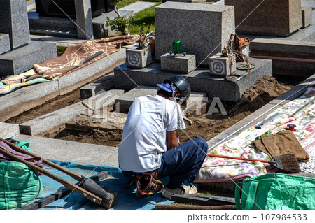 在墓地內的墳墓上進行維護工作的工匠。 107984533