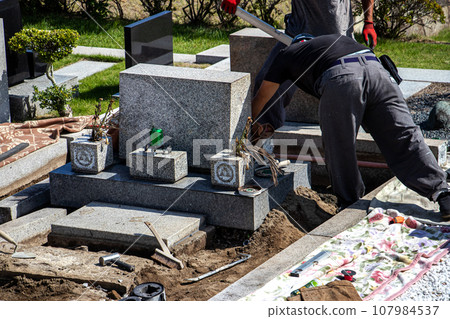 A craftsman who performs maintenance work on a grave inside a cemetery. A craftsman who performs maintenance work on a grave inside a cemetery. 107984537
