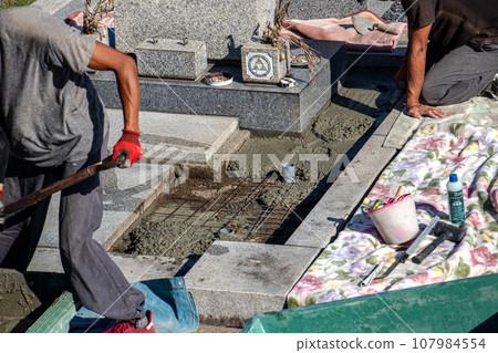 在墓地內的墳墓上進行維護工作的工匠。 107984554