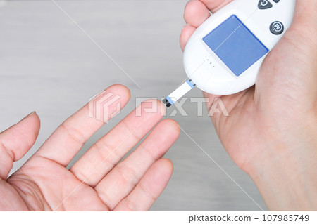 hand of people check diabetes and high blood glucose monitor with digital pressure gauge. Healthcare and Medical concept 107985749