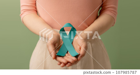 Ovarian and Cervical Cancer Awareness. Woman Holding Teal Ribbon on Lower Abdomen, Uterus, Female Reproductive System, Women's Health, PCOS and Gynecology Ovarian and Cervical Cancer Awareness. Woman Holding Teal Ribbon on Lower Abdomen, Uterus, Female Reproductive System, Women's Health, PCOS and Gynecology 107985787