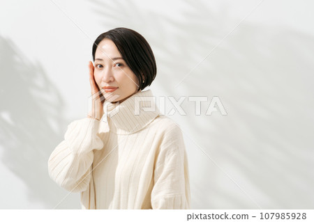 A smiling woman feeling the moisture in her skin 107985928