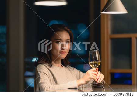 Young woman with wine glass at bar Young woman with wine glass at bar 107987013