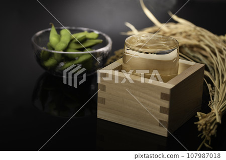 一杯清酒中的高品質日本清酒、冷清酒（黑色背景）和毛豆作為清酒的佐餐。 107987018