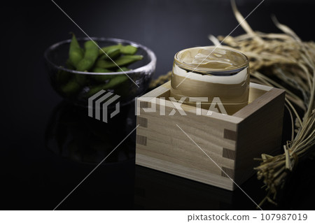 High-quality Japanese sake in a glass of sake cup (black background) with edamame as a snack 107987019