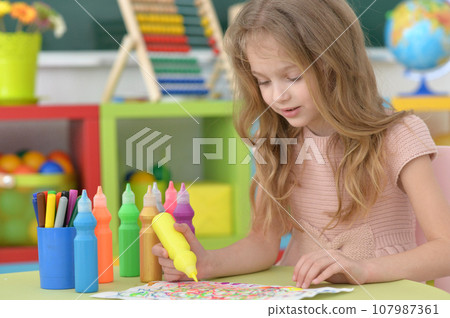 Portrait of cute girl drawing picture at home 107987361