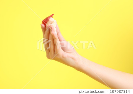 Hand with Sushi 107987514