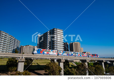 Osaka Monorail wrapped train passing by a residential area 107989806