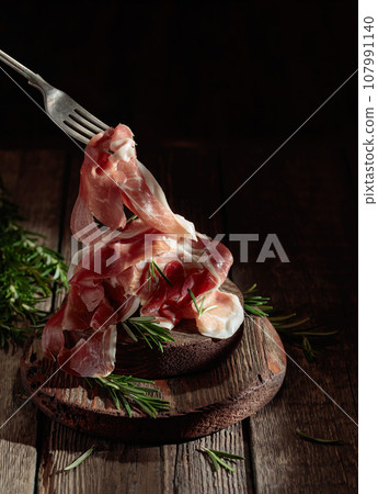 Italian prosciutto or Spanish jamon with rosemary. 107991140