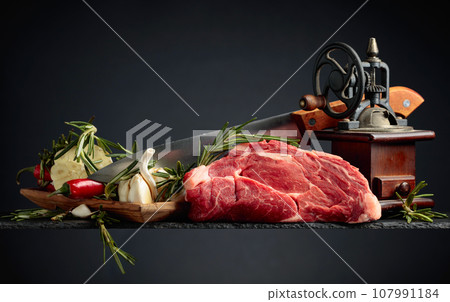 Raw beef meat steaks with rosemary, garlic, and pepper. 107991184