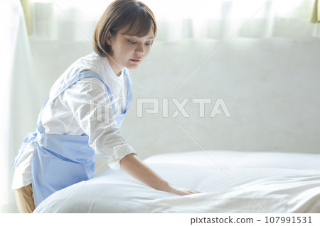 Cute woman making a bed Cute woman making a bed 107991531