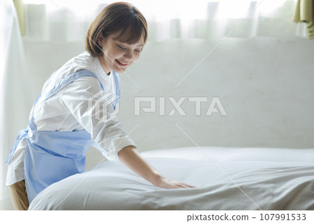 Cute woman making a bed 107991533