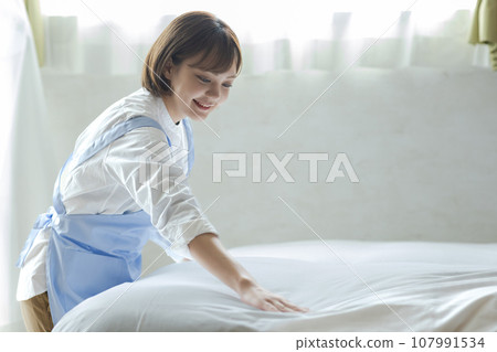 Cute woman making a bed Cute woman making a bed 107991534