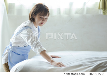 Cute woman making a bed 107991535