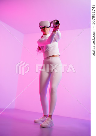 Woman wearing VR glasses practicing golf Woman wearing VR glasses practicing golf 107991742