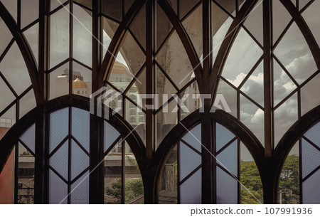Antique multicolored stained glass window panel are decorated in monastery chapel. 107991936