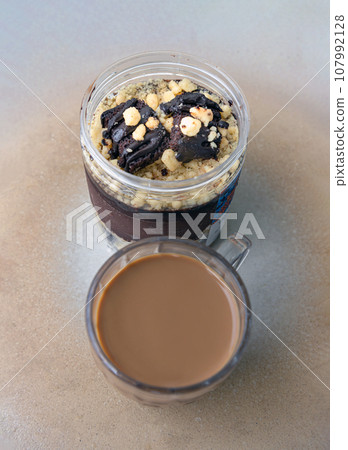 Good morning with Crumble dark chocolate brownie served with Coffee in glass cup on Ceramic tray. Good morning with Crumble dark chocolate brownie served with Coffee in glass cup on Ceramic tray. 107992128