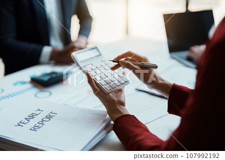 Team business adviser meeting to analyze and discuss the situation on the financial report n the meeting room with using calculator, documents, computer laptop in work Team business adviser meeting to analyze and discuss the situation on the financial report n the meeting room with using calculator, documents, computer laptop in work 107992192
