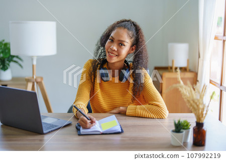 Portrait of African Americans using notebooks, pens to take notes and computers. to study through the Internet, online e learning concept Portrait of African Americans using notebooks, pens to take notes and computers. to study through the Internet, online e learning concept 107992219