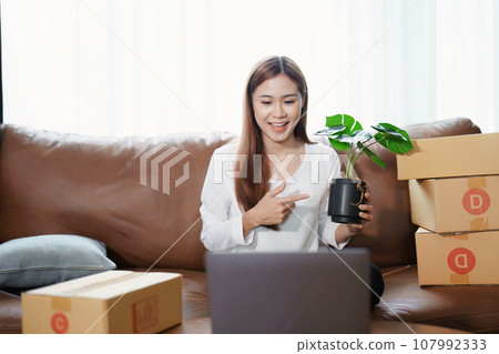 Starting small business entrepreneur of independent young Asian woman online seller using a computer showing products to a customer before making a purchase decision. SME delivery concept. Starting small business entrepreneur of independent young Asian woman online seller using a computer showing products to a customer before making a purchase decision. SME delivery concept. 107992333