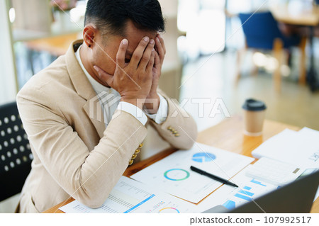 Portrait of sme business owner, man using computer and financial statements Anxious expression on expanding the market to increase the ability to invest in business. 107992517