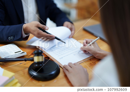Law and legitimacy, portrait of lawyer and client signing important contract documents. Law and legitimacy, portrait of lawyer and client signing important contract documents. 107992609