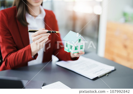 Guarantee, mortgage, agreement, contract, sign, real estate agent delivers the house to the customer after signing important contract documents. Guarantee, mortgage, agreement, contract, sign, real estate agent delivers the house to the customer after signing important contract documents. 107992842