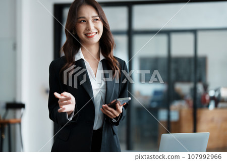 business owner or Asian female marketers are using business phones in office work. 107992966