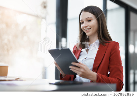 business owner or Asian female marketers are using tablet computer in office work. business owner or Asian female marketers are using tablet computer in office work. 107992989