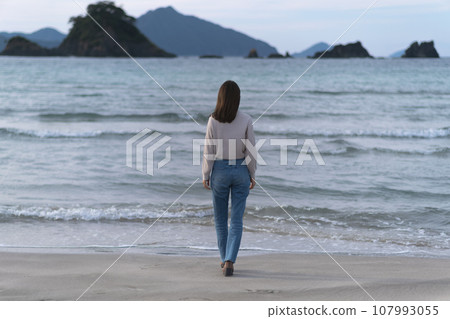 秋天,穿著喇叭牛仔褲在沙灘上行走的女子(福井縣若狹和田海灘) 秋天,穿著喇叭牛仔褲在沙灘上行走的女子(福井縣若狹和田海灘) 107993055