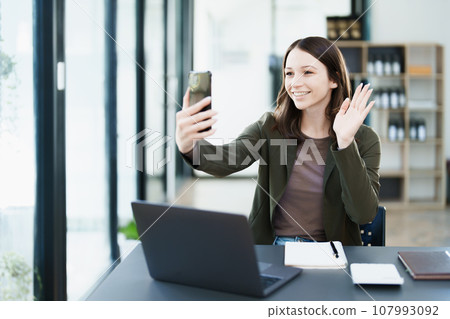 business owner or Asian female marketers are using business phones in office work. 107993092