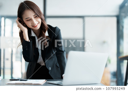 Portrait of a beautiful Asian teenage girl using computer for video conferencing at office. 107993249