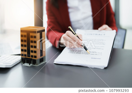 Guarantee, mortgage, agreement, contract, signed, real estate agent pointing to documents for customers to read the agreement before signing important documents. Guarantee, mortgage, agreement, contract, signed, real estate agent pointing to documents for customers to read the agreement before signing important documents. 107993293