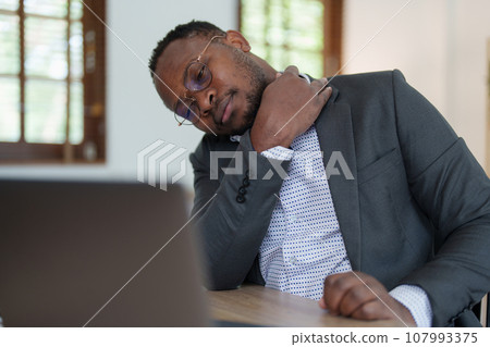 Burnout American African business man in stress works with many paperwork document, migraine attack, Freelance, work from home. Burnout American African business man in stress works with many paperwork document, migraine attack, Freelance, work from home. 107993375