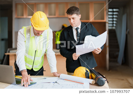 multi ethnic engineer brainstorming and measuring for cost estimating on blueprint and floor plan drawings about design architectural and engineering for houses and buildings. multi ethnic engineer brainstorming and measuring for cost estimating on blueprint and floor plan drawings about design architectural and engineering for houses and buildings. 107993707