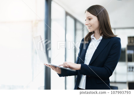 Excited businesswoman using computer laptop while in office, business concepts Excited businesswoman using computer laptop while in office, business concepts 107993793