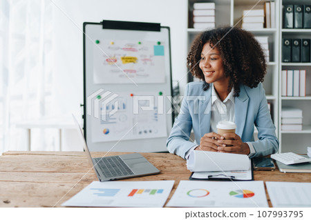 American African business woman using document, computer laptop, calculator, paperwork, documents, in winner and smiling Happy to be successful achievement success. finance and investment concepts. American African business woman using document, computer laptop, calculator, paperwork, documents, in winner and smiling Happy to be successful achievement success. finance and investment concepts. 107993795