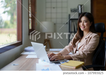 Young asian businesswoman manager, lawyer or company employee holding accounting bookkeeping documents checking financial data or marketing report working in office with laptop. Paperwork management. Young asian businesswoman manager, lawyer or company employee holding accounting bookkeeping documents checking financial data or marketing report working in office with laptop. Paperwork management. 107993825